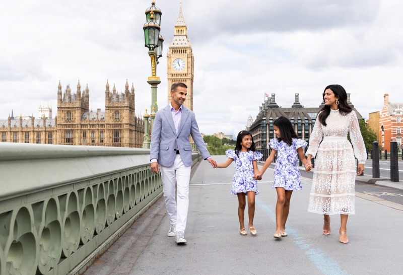 family of four, hand in hand, walking away from big ben