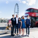 a man, lady, two boys and a girl with a red bus behind them and the london eye