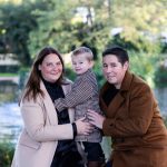 Boy with man and lady with trees behind them.
