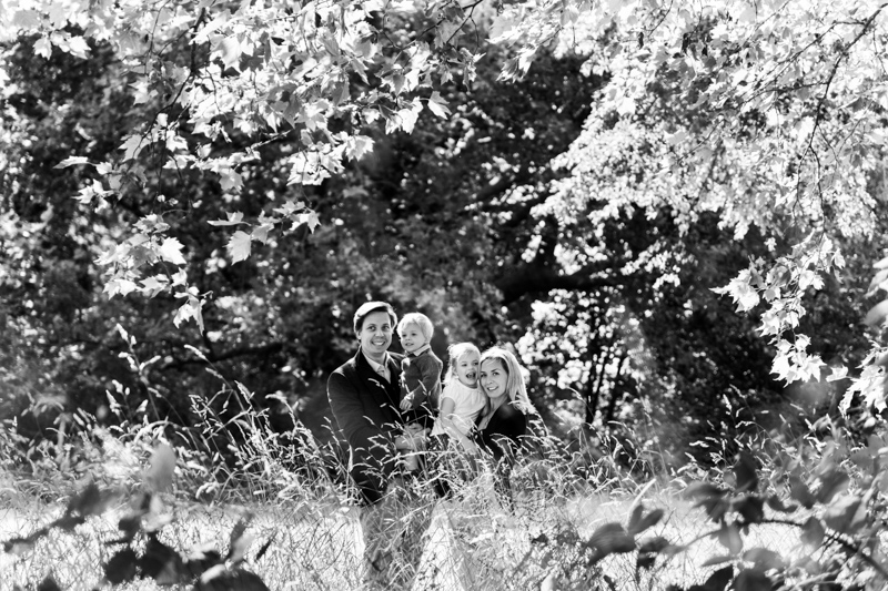 man, lady, girl and boy surrounded by trees and long grass