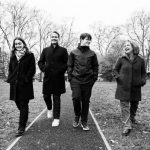 family of four walking together smiling