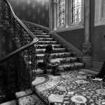 A girl sitting on a staircase with a lady photographing her