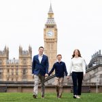 Mum, dad and son walking in front of the Houses of Parliament and Big Ben.